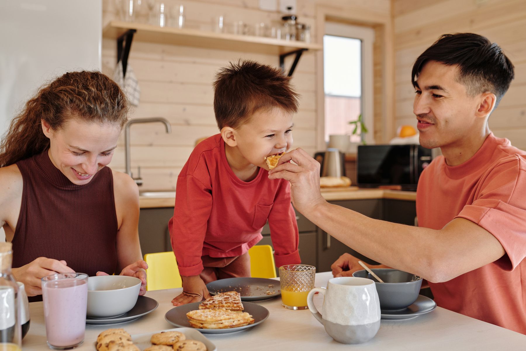 A happy family enjoying breakfast together at the dining table in their restored New Jersey home